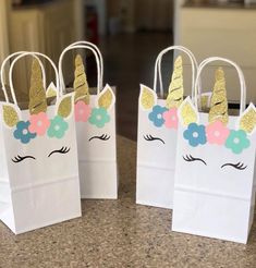 three bags with unicorn ears and flowers on them