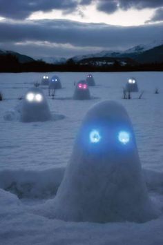 a group of snowmen with glowing eyes in the snow