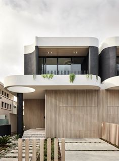 an architecturally designed building with wooden slats and plants on the balconies