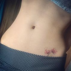 a woman's stomach with a small tree tattoo on it