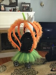 an orange and green tutu skirt sitting on top of a rug in front of a fireplace