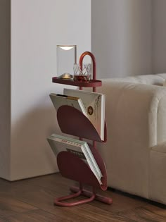 a table that has some kind of magazine holder on top of it, with a lamp in the corner