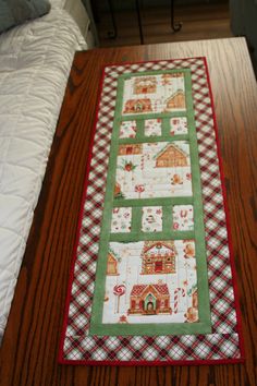 a quilted table runner sitting on top of a wooden table next to a bed