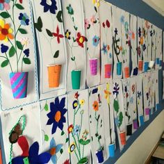 the wall is decorated with flowers and paper cups