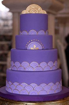 a three tiered purple and gold wedding cake