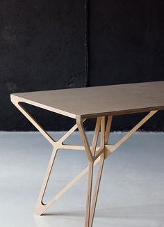 a white table sitting on top of a cement floor next to a black and white wall