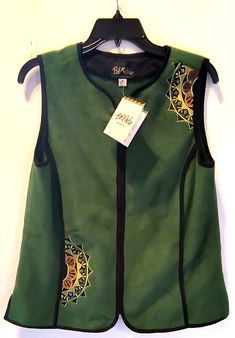 Bob Mackie Wearable Art Vest Add a unique and stylish touch to your casual outfit with this Bob Mackie Wearable Art Vest in size S. The green vest features an embroidered design that will surely catch the eye. The mid-length vest has a sleeveless cut and a full zip closure for a comfortable fit. Made with fleece fabric, this vest is perfect for all seasons, whether it's winter, summer, fall, or spring. This vest is a rare and unique piece that will surely impress. It has a regular fit, making it suitable for women of all sizes. The vest is not only fashionable but also practical, featuring outer shell material of unknown origin. This vest is a must-have addition to your wardrobe. Inquiries Welcome ~ Satisfaction Guaranteed ~ Thanks for Looking! Green Sleeveless Vest With Patchwork, Green Sleeveless Patchwork Vest, Green Winter Vest Top, Green Patchwork Vest For Spring, Spring Green Patchwork Vest, Green Vest Top For Fall, Sleeveless Cotton Outerwear For Festivals, Green Casual Cotton Vest, Green Embroidered Sleeveless Top