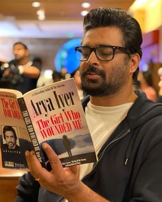 a man reading a book about the girl who won't die in an arena