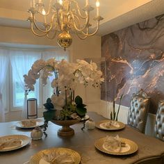 a dining room table with plates and flowers on it