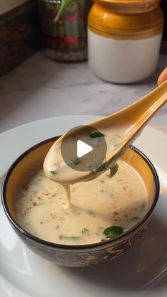 a spoon is being used to dip some food into a bowl