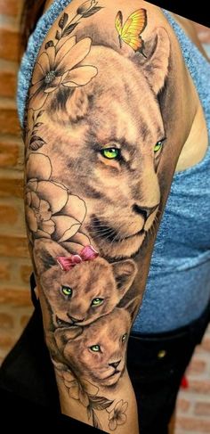 a woman's arm with a lion and cat tattoo on the left side of her body