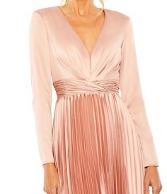 a woman wearing a pink dress with long sleeves and pleaing on the bottom,