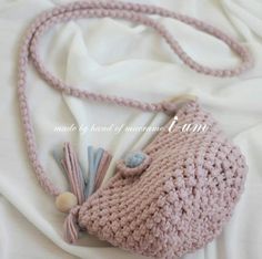 a crocheted purse with tassels on it laying on a white sheet