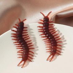 two red worms sitting on top of a white plate