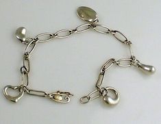 Authentic Vintage Tiffany & Co. Gorgeous Sterling Silver Elsa Peretti  Open Heart Eternal Circle Teardrop Bean & Sagittarius Charm Bracelet... Fully engraved:  TIFFANY & CO  925 signed: Elsa Peretti SPAIN on the back of the Sagittarius  Zodiac charm and TIFFANY & CO 925 ELSA PERETTI Spain on the clasp of the chain. ..It measures 7.5 inches long and weighs 11.3 grams of  warm Tiffany silver...  It is in very good condition and 100% authentic. Absolutely stunning...  Please take a look at my other Bean Bracelet, Sagittarius Zodiac, Vintage Tiffany, Elsa Peretti, Zodiac Sagittarius, Fine Jewelry Bracelets, Open Heart, Bracelets And Charms, Base Metal