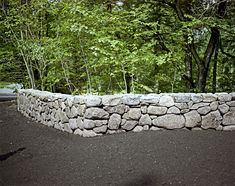 a stone wall with trees in the background