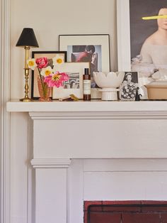 a fireplace mantel with pictures and candles on it