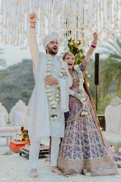 a man and woman standing next to each other in front of a chandelier