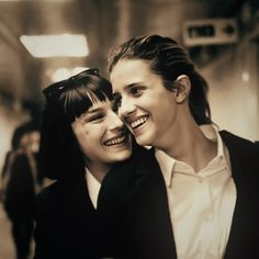 two young women are smiling and hugging each other