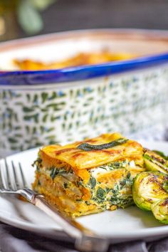 a white plate topped with a slice of quiche next to brussel sprouts