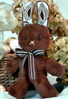 a teddy bear sitting on top of a basket filled with leaves and flowers in the background