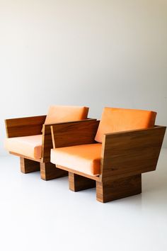 two wooden chairs sitting next to each other on top of a white floor covered ground