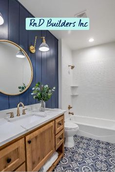 a bathroom with blue and white tile flooring, wooden cabinets and a round mirror above the sink