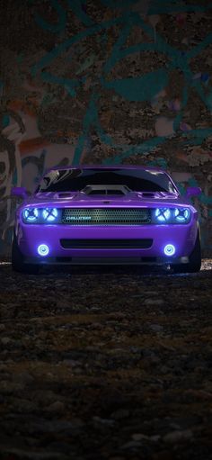 a purple sports car parked in front of a graffiti covered wall