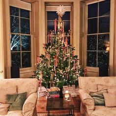 a living room with two couches and a christmas tree