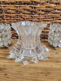 three glass vases sitting on top of a wooden table next to a wicker basket