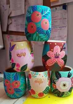 colorful painted cups sitting on top of a table