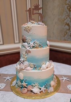 a three tiered cake with blue and white frosting