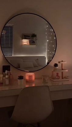 a mirror sitting on top of a desk next to a white chair and table with candles