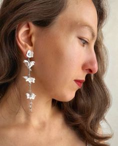 Delicate Long Silver Earrings with White Flowers in Boho Style ➢ Description: Elevate your boho style with these exquisite, delicate long earrings crafted in silver, featuring charming white flowers. These earrings are designed to complement any boho look with their lightweight and versatile design. ➢ Modular Design: These unique earrings can be worn in three different ways: Full Earring: Wear the complete earring with the dangling part for an elegant, bohemian vibe. Flower Stud Only: Opt for just the flower stud for a subtle, everyday look. Simple Stud: Wear the stud alone without the flower for a minimalist touch. ➢ Details: Material: Hypoallergenic jewelry alloy cover with silver Style: Boho Color: White flowers Weight: Ultra-light for comfortable wear ➢ Customization Options: Gold Vers Earrings For Bride, Elegant Bohemian, Long Silver Earrings, Floral Jewelry, Jewelry Bridesmaid, Etsy Bridesmaid Gifts, Hypoallergenic Jewelry, Wedding Jewelry Earrings, Earring Crafts