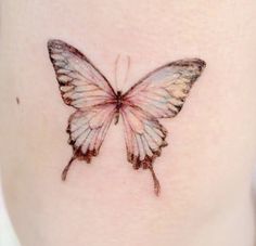 a small butterfly tattoo on the side of a woman's stomach