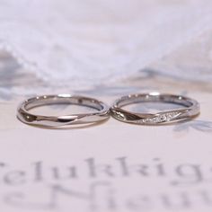 two wedding rings sitting on top of an open book