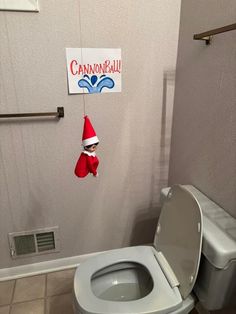 the elf is hanging over the toilet in the bathroom