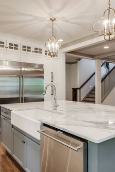 a kitchen with marble counter tops and stainless steel refrigerator freezer next to an island