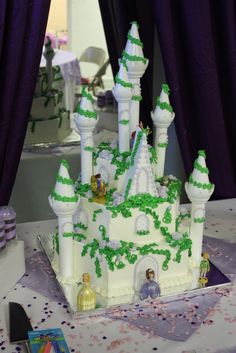 a cake that looks like a castle with green frosting and decorations on the top