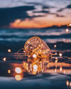 a light bulb floating on top of the ocean at night with its reflection in the water