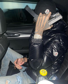 a man sitting in the back seat of a car holding a cell phone to his ear