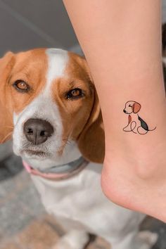 a dog with a small tattoo on it's leg is standing next to a woman