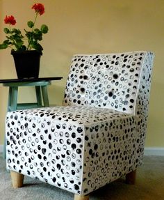 a white and black patterned chair next to a small table with flowers in the background