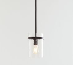 a small glass light fixture hanging from a black ceiling lamp with a white wall in the background