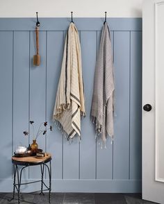 two towels hanging on the wall next to a table