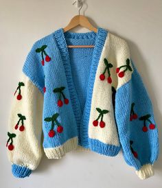 a blue and white sweater with cherries on it