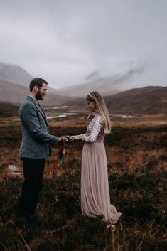 a man standing next to a woman in a field