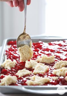 a person is spooning some food out of a pan with crumbs on it