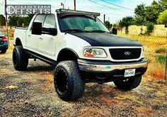 a white truck parked on top of a dirt road