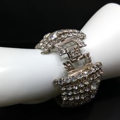 *Description: This is a gorgeous clear rhinestone wide gold plated bracelet from the 1950s which would look beautiful at a wedding or any special event. This bracelet is an unsigned designer bracelet which has a very faint gold tone which only shows up in photos as it looks silver tone. My first thought was that it was rhodium plated but when it was tested, it tested at 22K gold plate. We have a similar Weiss bracelet that is also wide, silver tone, and has the same four rhinestone clasp. So, th Vintage Cubic Zirconia Bracelet For Formal Occasions, Vintage Cubic Zirconia Formal Bracelet, Vintage Cubic Zirconia Bracelets With Diamond Accents, Glamorous Formal Bracelets With Rhinestones, Glamorous Diamond Crystal Bracelet For Formal Occasions, Glamorous Rhinestone Bracelets For Formal Occasions, Glamorous Rhinestone Cuff Bracelet For Evening, Glamorous Evening Bling Bracelets, Glamorous Crystal Cuff Bracelet For Formal Occasions